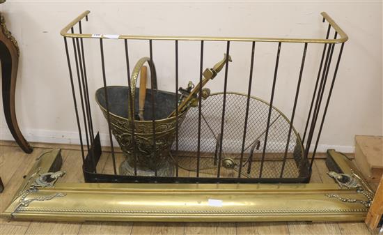 A brass fire surround, a guard, a bucket and quantity of fire irons W.94cm